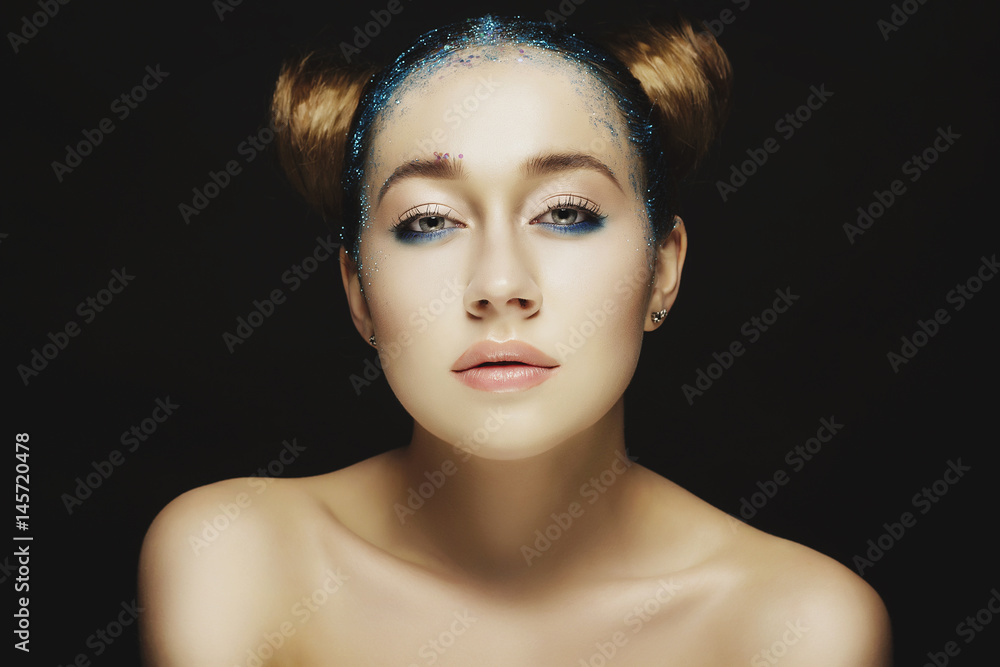 Portrait of beautiful woman with blue make up on eyes and blue glitter in hair. Beauty concept. Portrait of beautiful woman with blue make up on eyes and blue glitter in hair. Beauty concept.