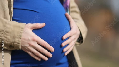 Wallpaper Mural Girl in blue shirt with maternal tenderness carees affectionately carees her big stomach with child, Steady cam, slow mo shot Torontodigital.ca