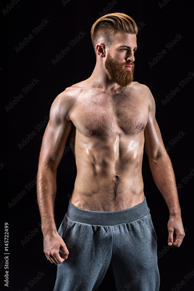 handsome bearded sportsman posing and standing isolated on black in studio handsome bearded sportsman posing and standing isolated on black in studio