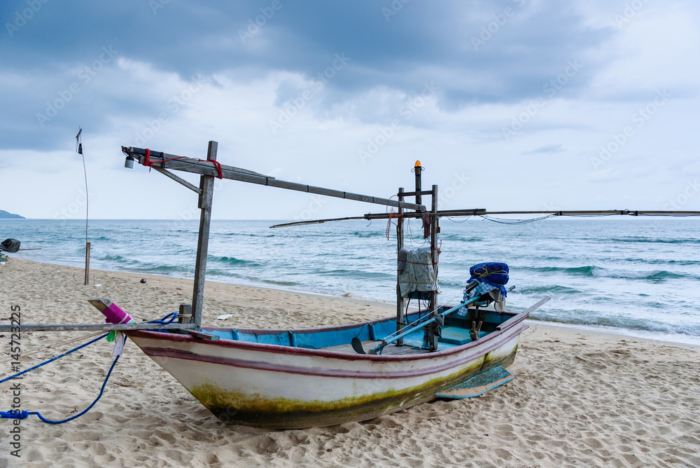 Obraz premium Fishing boats on the beach over cloudy sky at Prachuap Khiri Khan, Thailand.