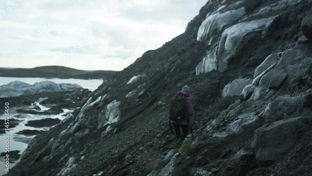 woman hiking near glacier field in Iceland woman hiking near glacier field in Iceland