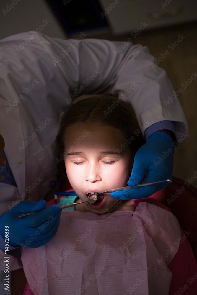 Obraz premium Dentist examining a young patient with tools