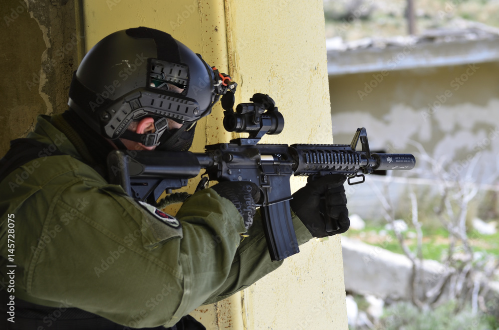 Fototapeta premium Soldier aim target red dot scope militery helmet gloves and green uniform