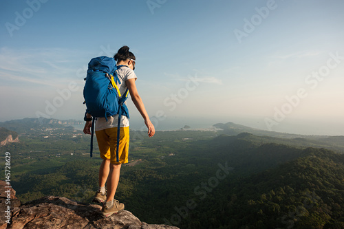successful woman hiker enjoy the view on mountain peak cliff