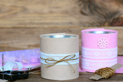 Recycled tin cans for storage. Easy and cheap idea for beautiful decorating old things. Recycled craft concept. Wooden background