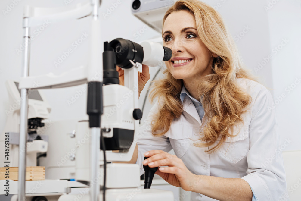 Fototapeta premium Excited young specialist employing professional equipment