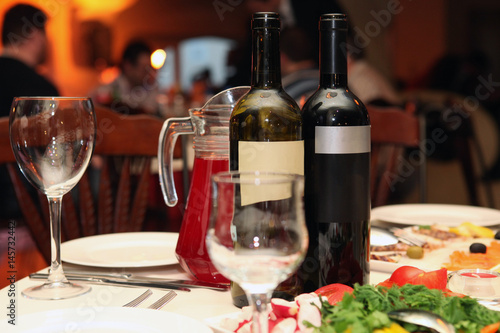 Two bottles of wine on a table in a restaurant