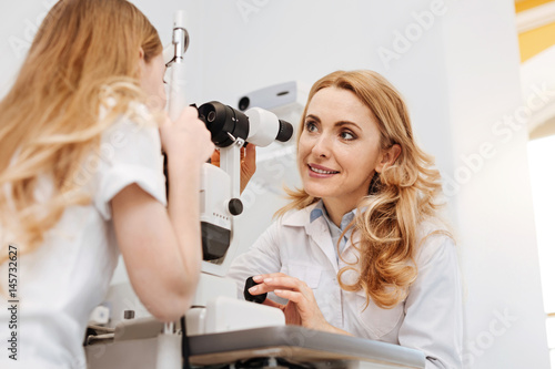 Sweet skillful ophthalmologist giving her patient instructions
