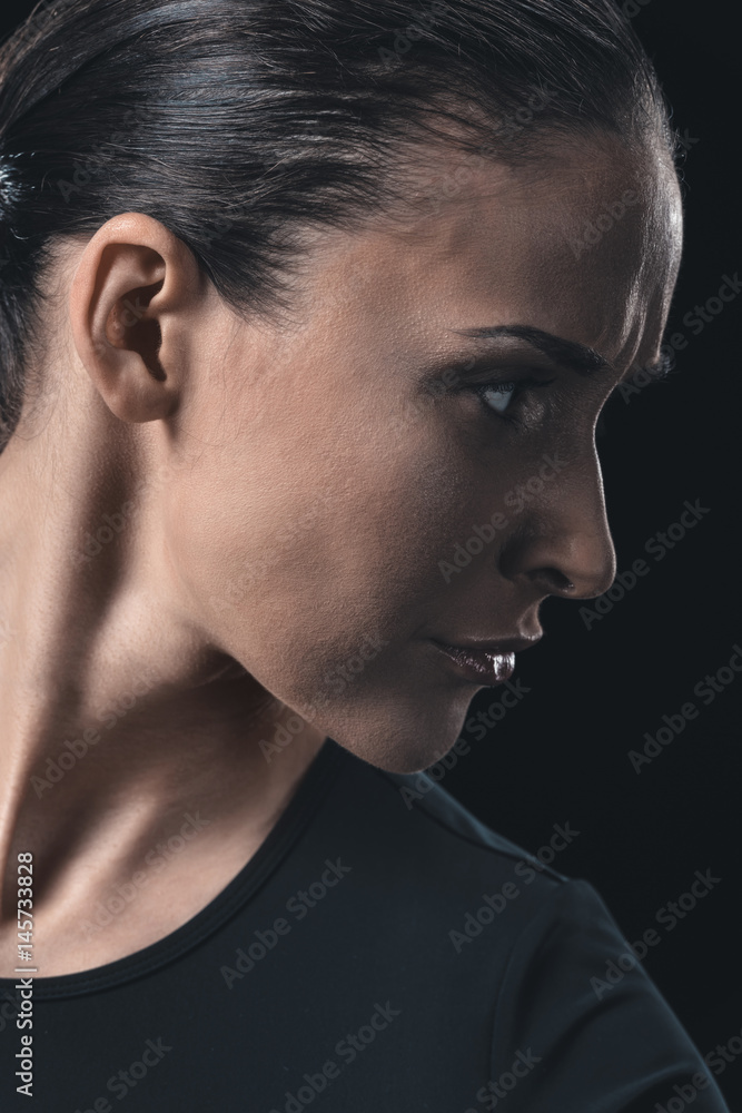 side view portrait of attractive young woman isolated on black. side view portrait of attractive young woman isolated on black.