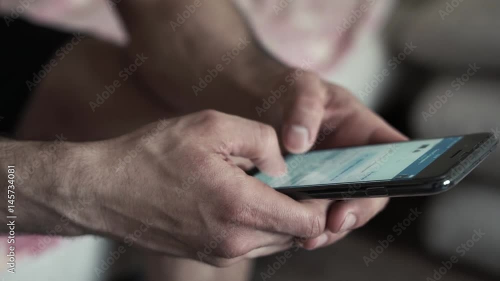 Young man sitting in bed using smartphone Young man sitting in bed using smartphone