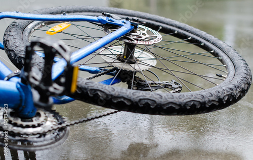 Bicycle lying on wet concrete after accident