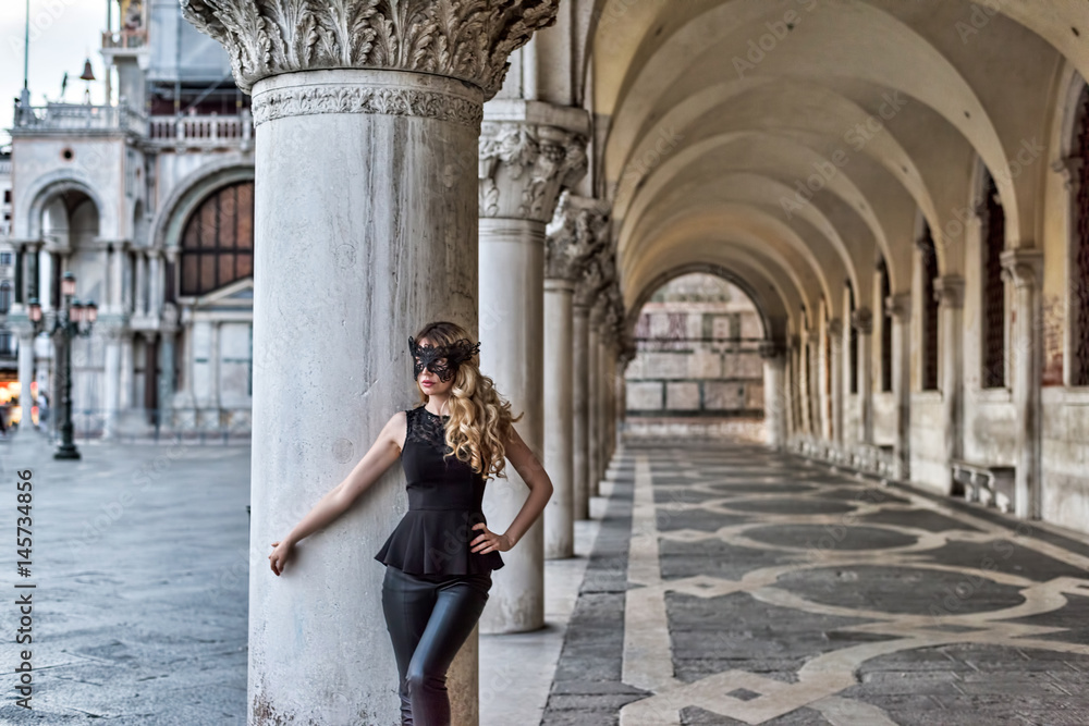 Girl wearing a black mask in San Marco Square, Italy