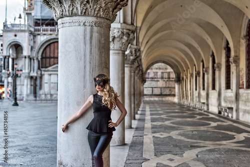 Girl wearing a black mask in San Marco Square, Italy © castecodesign