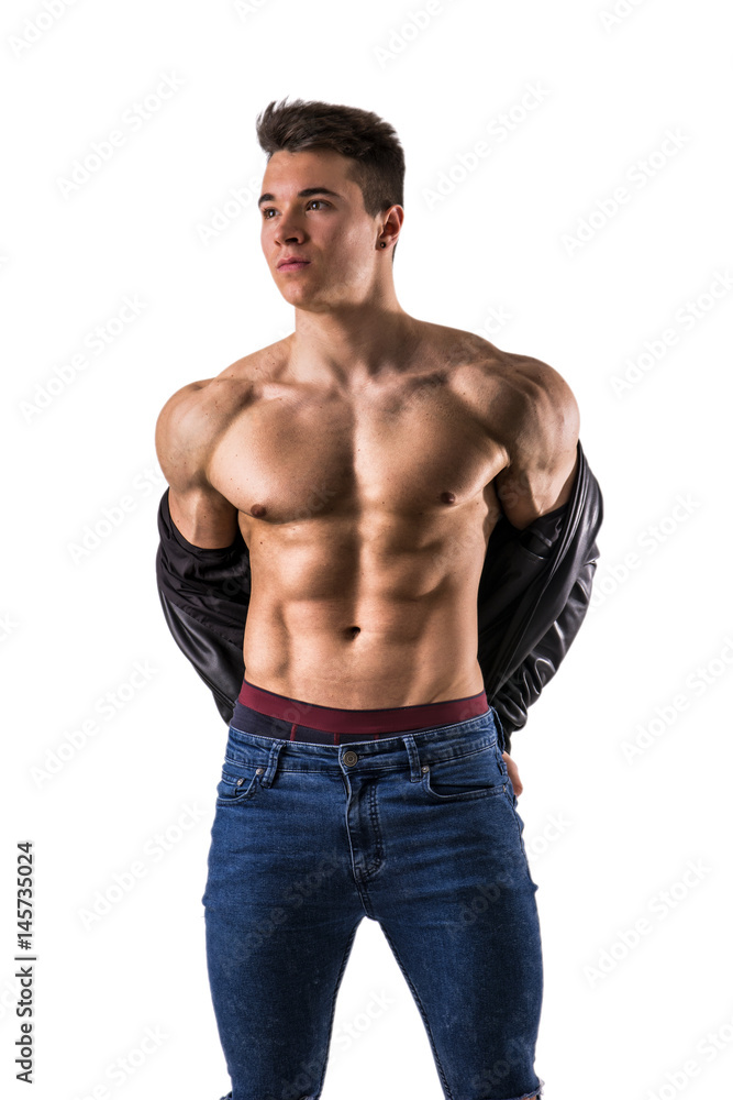 Handsome young muscular man shirtless wearing jeans, taking off leather jacket on naked muscle torso, isolated on white background in studio shot Handsome young muscular man shirtless wearing jeans, taking off leather jacket on naked muscle torso, isolated on white background in studio shot