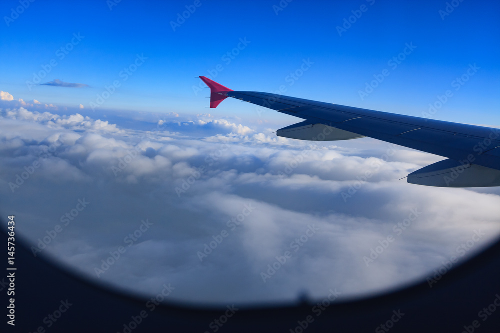 Fototapeta premium Beautiful view through Passenger plane window above the clouds