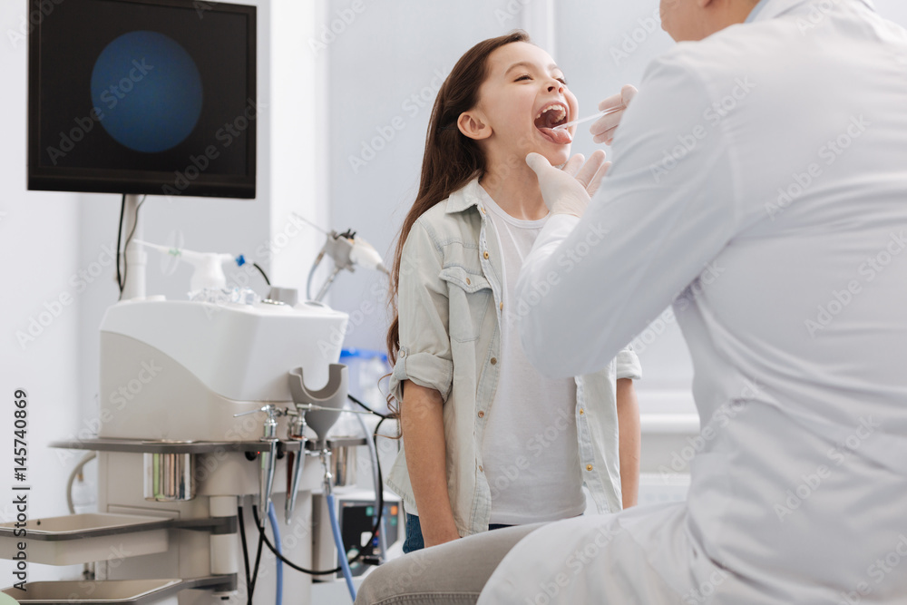 Competent doctor examining throat of little girl Competent doctor examining throat of little girl
