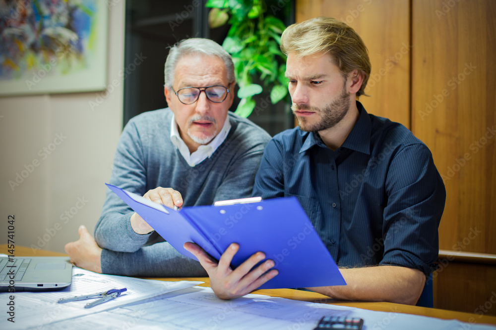 Businessman showing a document to his colleague Businessman showing a document to his colleague