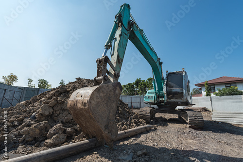 excavator on construction site  digger on gravel heap with shovel