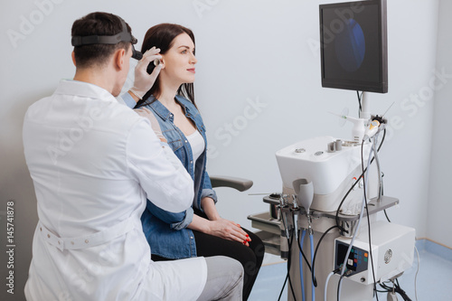 Photography Side view of medical examination leading be ENT specialist