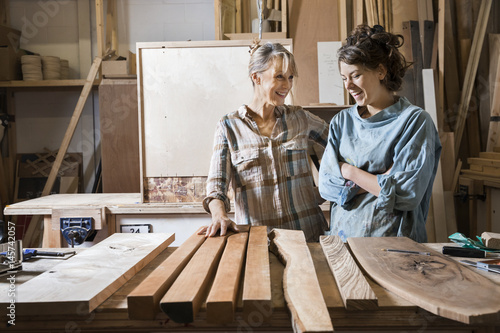 Two women choosing wood from a selection in a workshop photo