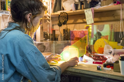 Young woman looking at materials in a craft workshop