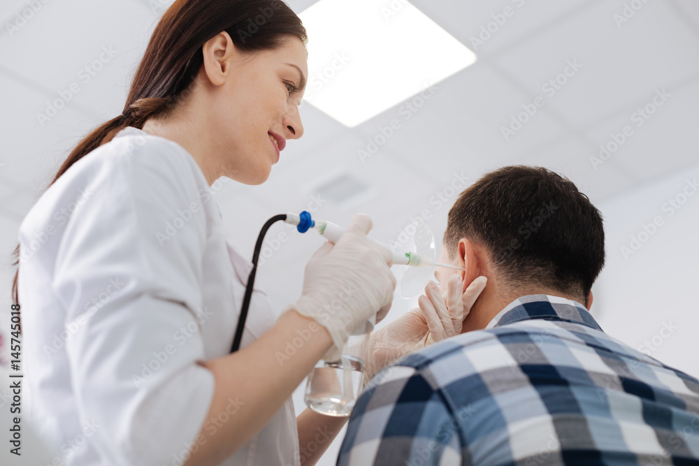 Fototapeta premium Delighted otolaryngologist standing near her patient