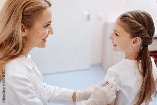 Attractive family doctor vaccinating her patient against diseases