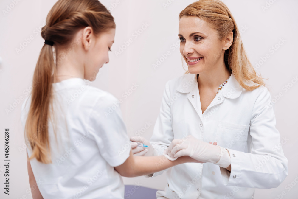 Smiling girl giving her hand for inoculation Smiling girl giving her hand for inoculation