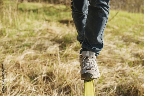 Slacklining is a practice of balancing, in which nylon or polyester fabric stretched between two anchor points is commonly used. People walk on it and do tricks