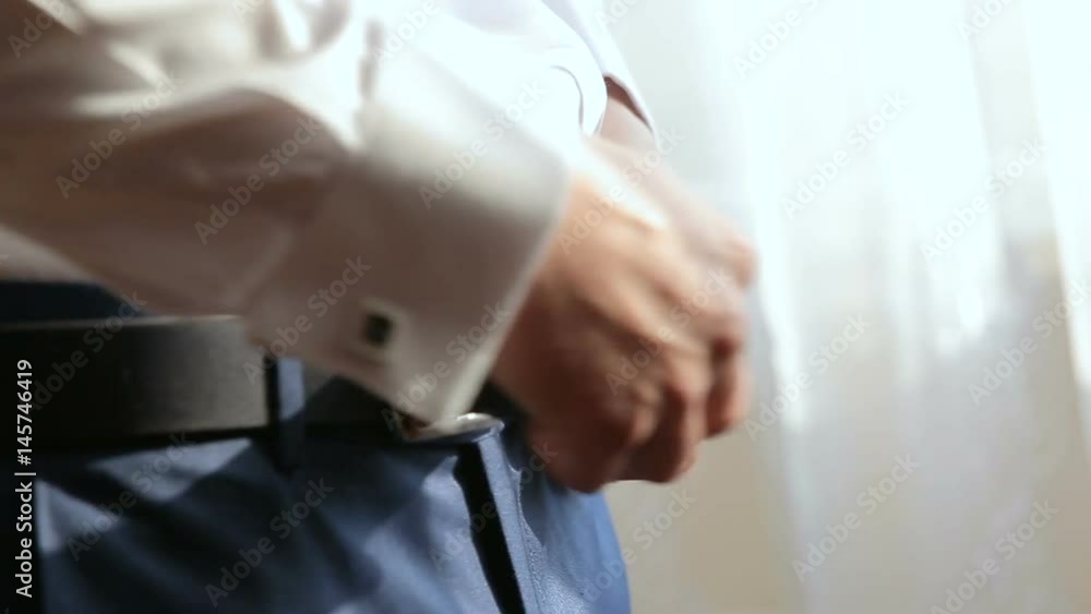 Man fastening belt on his trousers Man fastening belt on his trousers