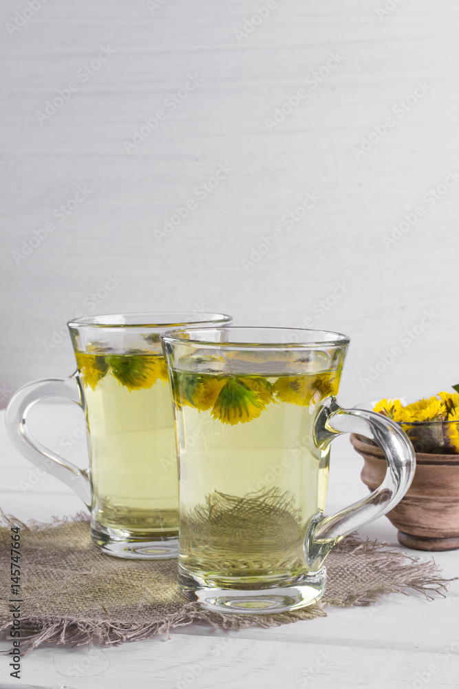 Two cups of herbal tea with coltsfoot (or Tussilago) flowers Two cups of herbal tea with coltsfoot (or Tussilago) flowers
