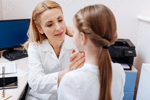 Portrait of competent doctor while examining throat