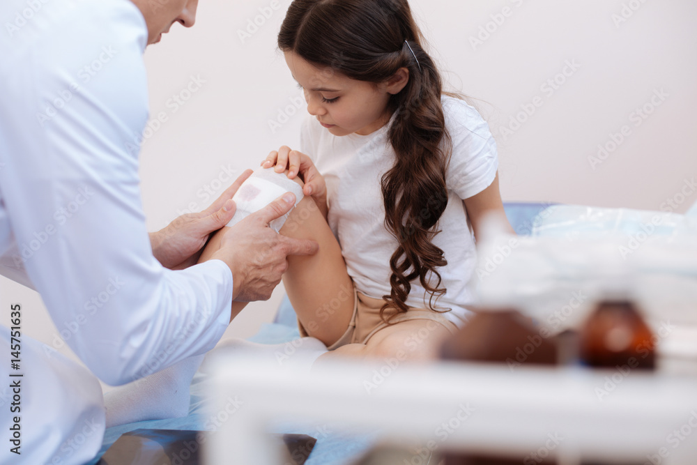 Experienced male doctor helping his young patient
