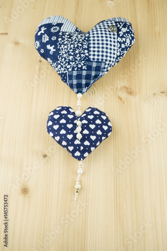 Zwei blau gemusterte Herzen auf Holzhintergrund, Textfreiraum, vertikal