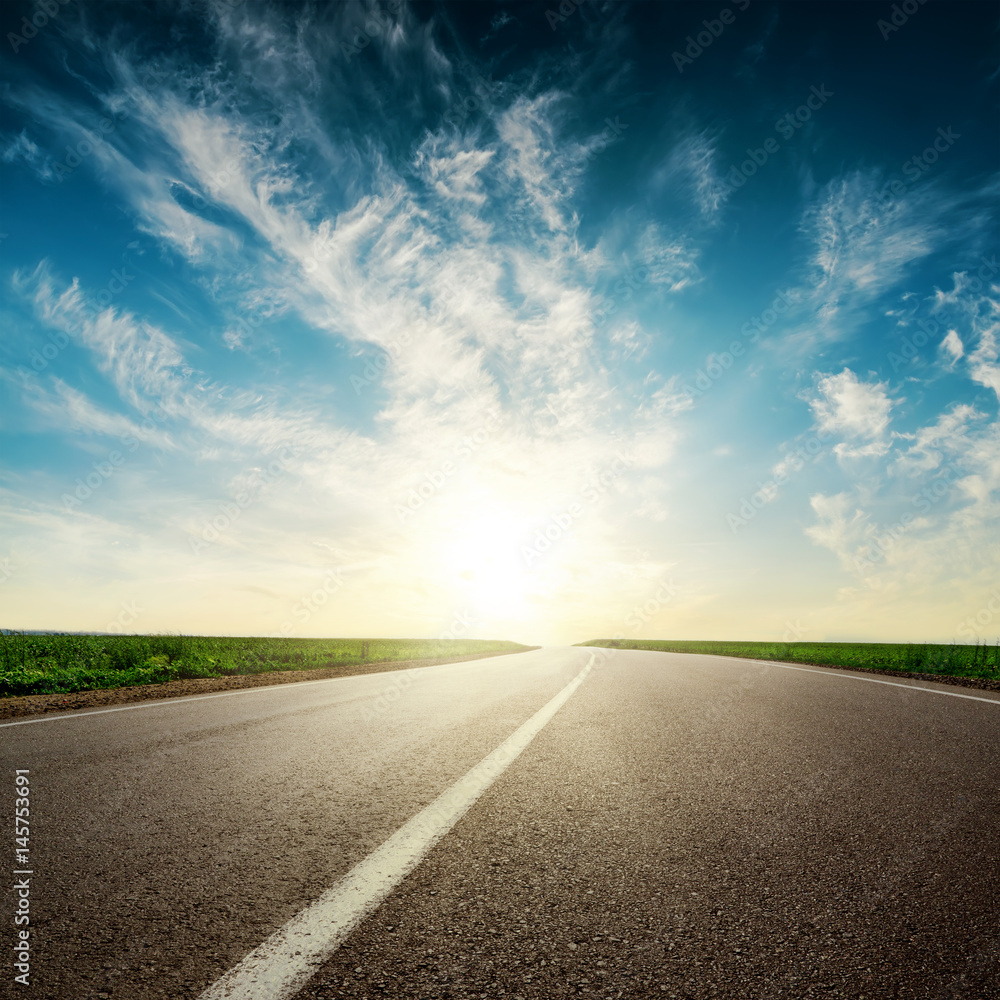 sunset in clouds over asphalt road