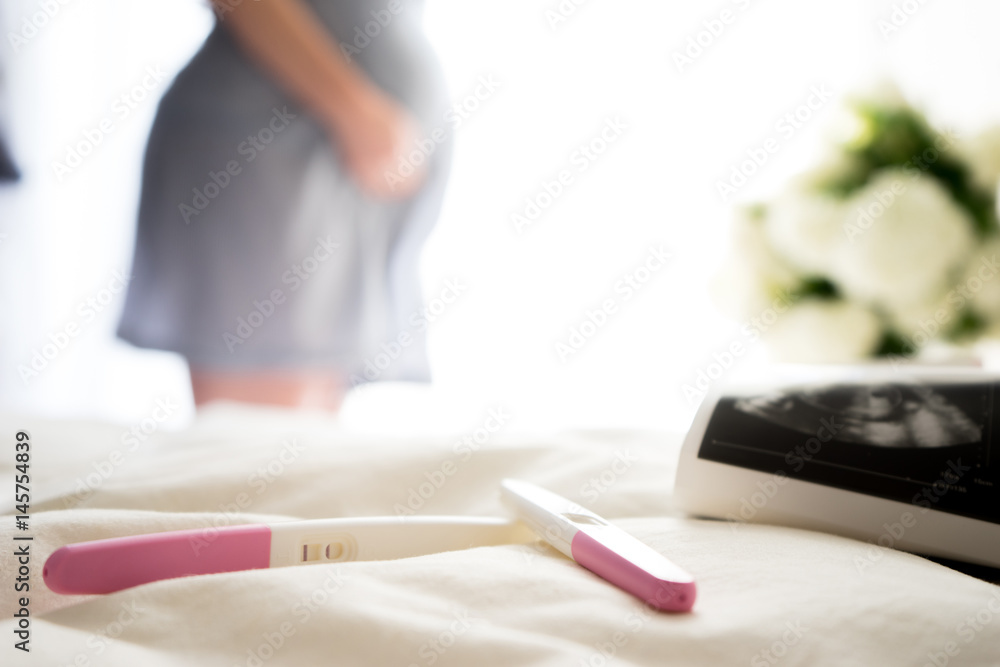 Close up of ultrasound scan  and positive pregnancy tests