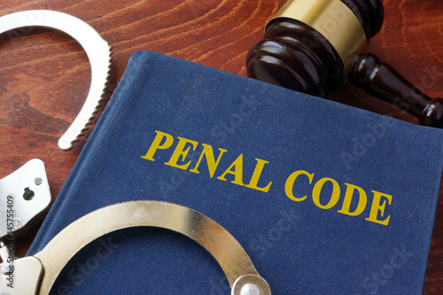 Cuffs and book with the title Penal code. Criminal law concept. photo