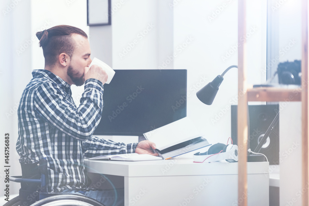 Disabled young man reading book at home