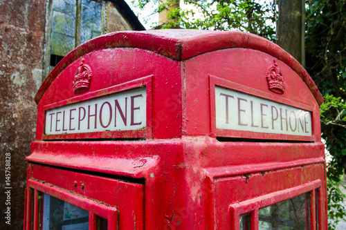 Wallpaper Mural The roof and sign of a traditional, red London telephone box in a countryside setting that is showing signs of wear and tear. Torontodigital.ca