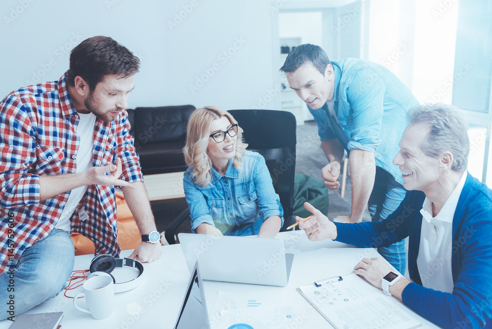 INvolved positive colleagues discussing project together INvolved positive colleagues discussing project together