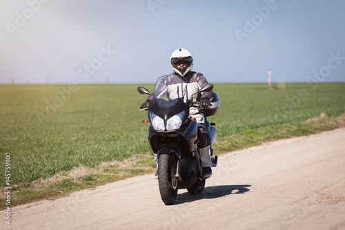 Biker riding on a motorcycle. Driving the empty road on a motorcycle tour journey