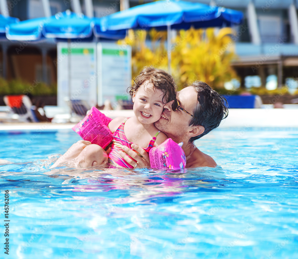 Handsome dad swimming with a cute daughter