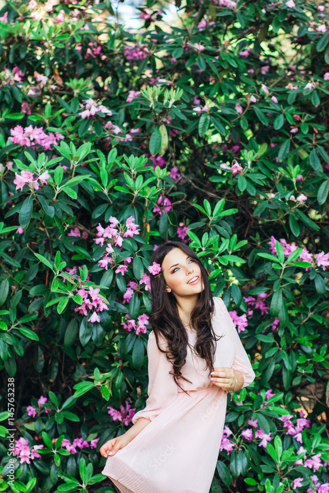 Portrait of young beautiful woman posing among blooming trees Portrait of young beautiful woman posing among blooming trees