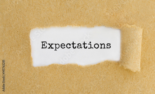 Fotografie Text Expectations appearing behind ripped brown paper.