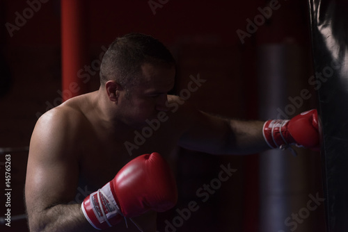 kick boxer training on a punching bag © .shock