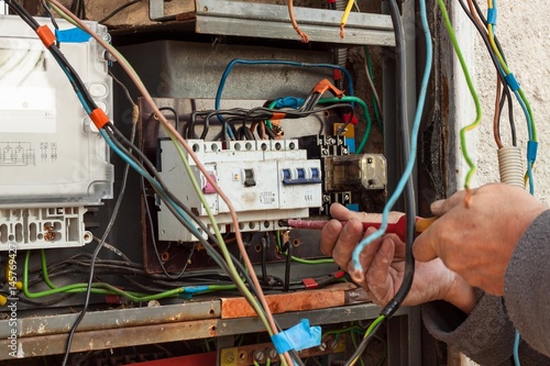 Repair of old electrical switchgear. An electrician replaces old electrical wiring devices.
