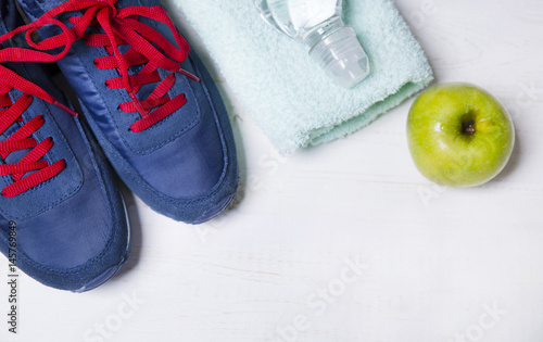 Sneakers, a towel, an apple and water