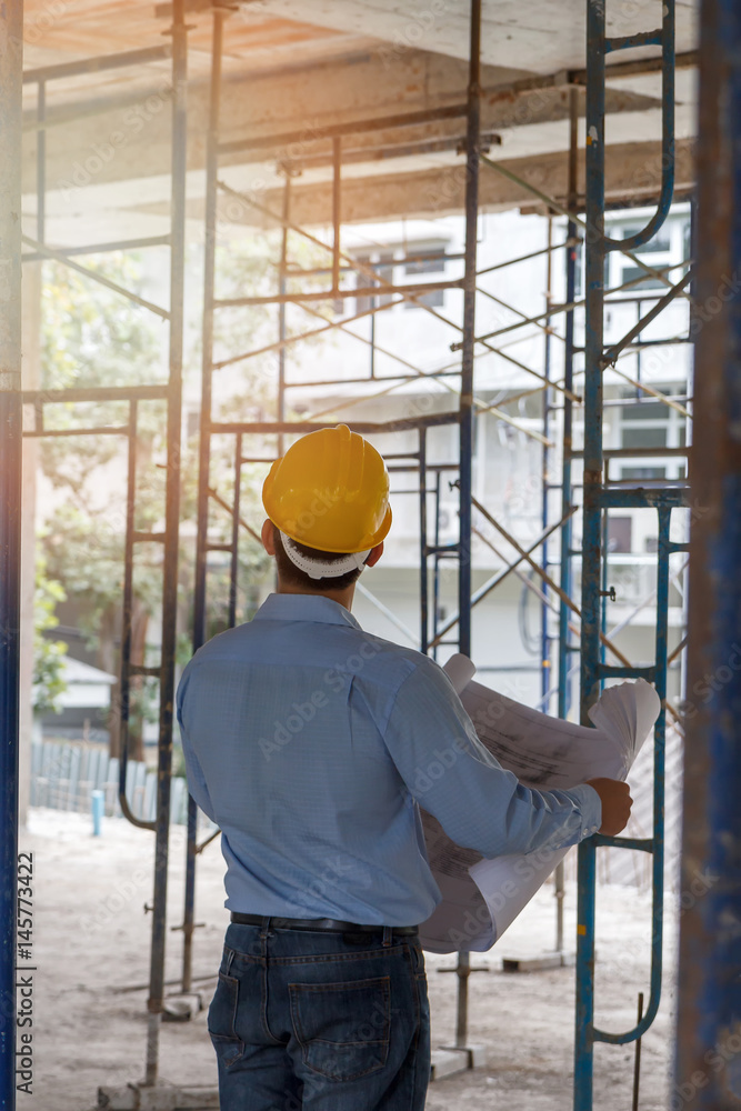 Engineer with blueprint in building construction site Engineer with blueprint in building construction site
