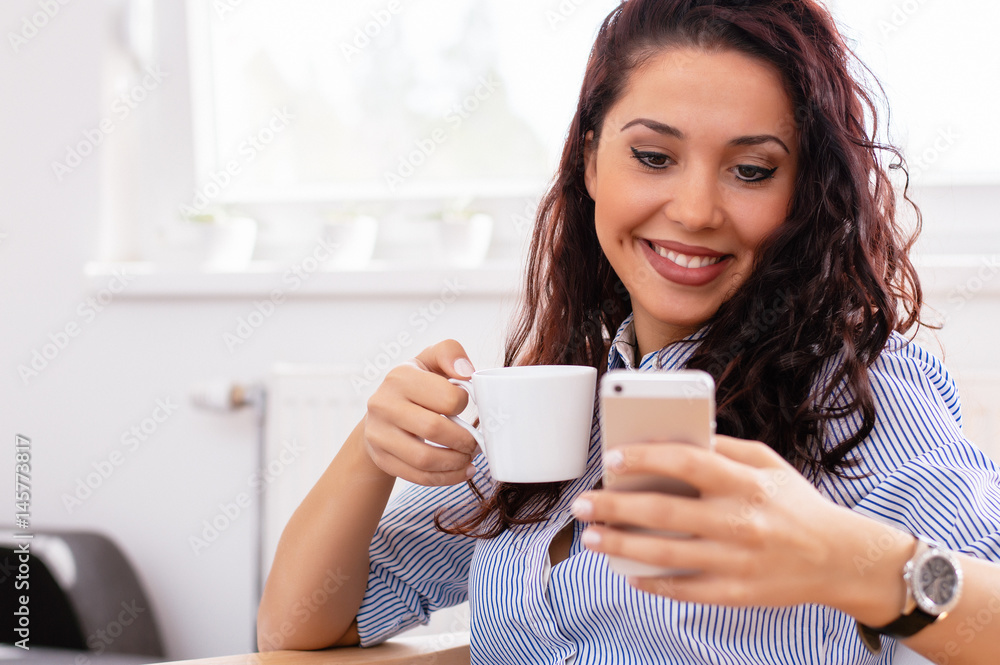 Enjoying time at home. Beautiful young smiling woman using mobile at home Enjoying time at home. Beautiful young smiling woman using mobile at home