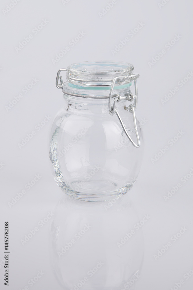 Clear glass empty bottle on a white surface. Bottle isolated on white background. Clear glass empty bottle on a white surface. Bottle isolated on white background.